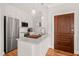Well-equipped kitchen with white cabinetry, marble countertops, stainless steel appliances, and modern lighting at 605 Smedes Pl # A, Raleigh, NC 27605