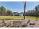 Scenic backyard with a view of the house and lush green lawn with garden and seating area at 6480 Beaver Creek Rd, New Hill, NC 27562