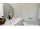 Contemporary powder room with a round mirror, modern fixtures, and a gray vanity at 6480 Beaver Creek Rd, New Hill, NC 27562