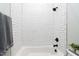 Full bathroom with white subway tile, a shower-tub combination, and sleek matte black hardware at 6480 Beaver Creek Rd, New Hill, NC 27562