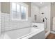 An elegant bathroom features a white tiled shower, a soaking tub, and a white framed window at 6480 Beaver Creek Rd, New Hill, NC 27562