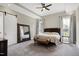 An airy primary bedroom with neutral tones, carpeted floors, ceiling fan, and large windows at 6480 Beaver Creek Rd, New Hill, NC 27562