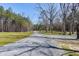 Gravel driveway leading to the house with surrounding grass and woods at 6480 Beaver Creek Rd, New Hill, NC 27562