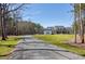 A long driveway leading up to a lovely white home surrounded by trees at 6480 Beaver Creek Rd, New Hill, NC 27562
