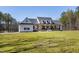 Front exterior view of the elegant farmhouse with dormer windows and a welcoming porch at 6480 Beaver Creek Rd, New Hill, NC 27562