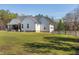 Exterior view of a white home with a back porch, garage, and windmill at 6480 Beaver Creek Rd, New Hill, NC 27562