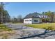 Charming white farmhouse with a three-car garage, covered porch, and expansive front yard at 6480 Beaver Creek Rd, New Hill, NC 27562