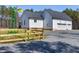 Exterior view of a white home with a windmill and a three-car garage at 6480 Beaver Creek Rd, New Hill, NC 27562