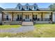 Beautiful modern farmhouse with a welcoming porch, gray roof, black railings, and lovely landscaping at 6480 Beaver Creek Rd, New Hill, NC 27562