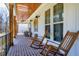 Spacious covered porch featuring brick flooring, rocking chairs, and wooden ceiling at 6480 Beaver Creek Rd, New Hill, NC 27562