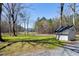 Scenic front yard featuring a storage shed and a view of the charming white farmhouse at 6480 Beaver Creek Rd, New Hill, NC 27562