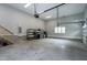 Large garage with high ceilings, ample storage shelving, and stairs to additional space at 6480 Beaver Creek Rd, New Hill, NC 27562