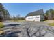 Spacious three-car garage beside home with gravel driveway and green grass at 6480 Beaver Creek Rd, New Hill, NC 27562