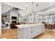 An open-concept kitchen and living space, with a large center island, fireplace and wood flooring at 6480 Beaver Creek Rd, New Hill, NC 27562