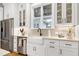 Kitchen area showcasing a white farmhouse sink, stainless steel appliances and white shaker cabinets at 6480 Beaver Creek Rd, New Hill, NC 27562