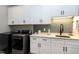 Laundry room features modern washer and dryer, ample white cabinetry, and stylish blue subway tile backsplash at 6480 Beaver Creek Rd, New Hill, NC 27562