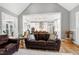 Open-concept living room with hardwood floors flowing into a kitchen with white cabinetry and a central island at 6480 Beaver Creek Rd, New Hill, NC 27562