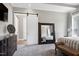 Bright main bedroom with a barn door, a dresser with decorations, and a large mirror at 6480 Beaver Creek Rd, New Hill, NC 27562