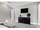 The main bedroom features neutral-toned walls, and a large flat screen television above a brown dresser at 6480 Beaver Creek Rd, New Hill, NC 27562