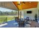 Wide angle view of a covered patio with brick floor, ceiling fan, television, and outdoor furniture at 6480 Beaver Creek Rd, New Hill, NC 27562