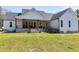 Back of home with covered porch, brick foundation, and black iron railing at 6480 Beaver Creek Rd, New Hill, NC 27562