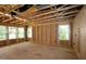 View of unfinished room featuring wood framing, plywood walls, and several windows allowing natural light in at 6960 Doddridge Ln # 15, Cary, NC 27519
