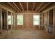 Unfinished room with wood framing, plywood walls, and bright windows ready for customization at 6960 Doddridge Ln # 15, Cary, NC 27519