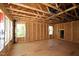Spacious unfinished room featuring plywood subfloor, wood framing, exposed ceiling, and several windows at 6960 Doddridge Ln # 15, Cary, NC 27519