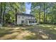 Back of the house with sunroom and backyard is partially shaded by trees at 721 Blenheim Dr, Raleigh, NC 27612