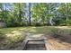 A peaceful backyard features trees, a brick retaining wall and flower bushes at 721 Blenheim Dr, Raleigh, NC 27612