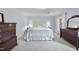 Spacious bedroom featuring light blue walls, carpet, and classic dark wood furniture at 721 Blenheim Dr, Raleigh, NC 27612