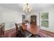 Elegant dining room featuring a wooden table set on a vibrant rug, illuminated by a classic chandelier and natural light at 721 Blenheim Dr, Raleigh, NC 27612