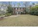 Traditional brick home with a well-maintained lawn, complemented by mature trees and a welcoming front entrance at 721 Blenheim Dr, Raleigh, NC 27612