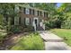 A beautiful brick home with black shutters, manicured bushes, and front yard at 721 Blenheim Dr, Raleigh, NC 27612