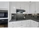 Modern kitchen featuring black stovetop, stainless appliances and white cabinets at 721 Blenheim Dr, Raleigh, NC 27612