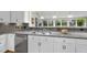 Kitchen with granite countertop, stainless steel sink, white cabinets and modern appliances at 721 Blenheim Dr, Raleigh, NC 27612