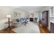 Comfortable living room featuring hardwood floors, shuttered windows, and a neutral color palette with accent pillows at 721 Blenheim Dr, Raleigh, NC 27612