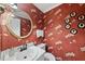 Charming powder room with unique wallpaper, gold round mirror, and decorative accents at 721 Blenheim Dr, Raleigh, NC 27612