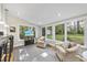 Bright sunroom with large windows, comfortable seating, and views of the lush backyard at 721 Blenheim Dr, Raleigh, NC 27612