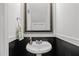 Powder room with a pedestal sink, mirror, and half wall with dark paint at 7628 Winners Edge St, Raleigh, NC 27617