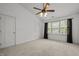 This spacious bedroom features neutral carpeting, a ceiling fan, and a bright window at 7628 Winners Edge St, Raleigh, NC 27617
