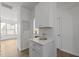 Modern kitchen featuring white cabinets, stainless steel appliances, and a light-filled adjacent living space at 7628 Winners Edge St, Raleigh, NC 27617