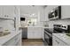 Modern kitchen with stainless steel appliances, white cabinets, subway tile backsplash, and a farmhouse sink at 7628 Winners Edge St, Raleigh, NC 27617
