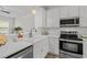 Modern kitchen with stainless steel appliances, white cabinets, subway tile backsplash, and a farmhouse sink at 7628 Winners Edge St, Raleigh, NC 27617