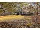 An ample-sized lawn is viewed from the back, accented by a screened porch and mature trees at 765 Carlton St, Clayton, NC 27520
