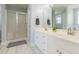 Bright bathroom featuring a double vanity, white cabinets and a glass-enclosed shower at 765 Carlton St, Clayton, NC 27520