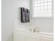 Bathroom featuring a white tub with tiled surround, chrome fixtures, and a towel rack at 765 Carlton St, Clayton, NC 27520