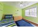 Cozy bedroom with bright green walls, hardwood floors, and a large window at 765 Carlton St, Clayton, NC 27520