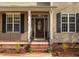 Elegant front entry showcasing a decorative glass door, brick steps, and black shutters at 765 Carlton St, Clayton, NC 27520