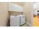 Bright laundry room featuring modern washer and dryer, storage cabinets and access to the living area at 765 Carlton St, Clayton, NC 27520